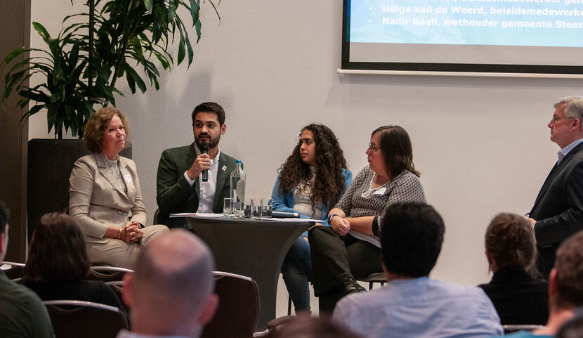 Panel van vier gemeentevertegenwoordigers tijdens de bijeenkomst van het Platform Gemeenten en Mensenrechten, die vertellen over hun aanpak tegen armoede.