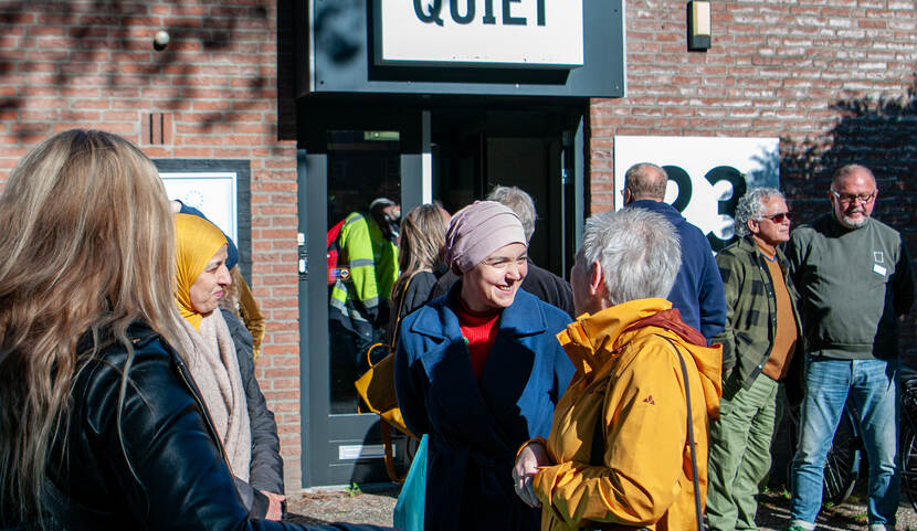 Wethouder Esmah Lahlah van de gemeente Tilburg in gesprek met bezoekers tijdens een gemeenschappelijke lunch van Quiet Tilburg.