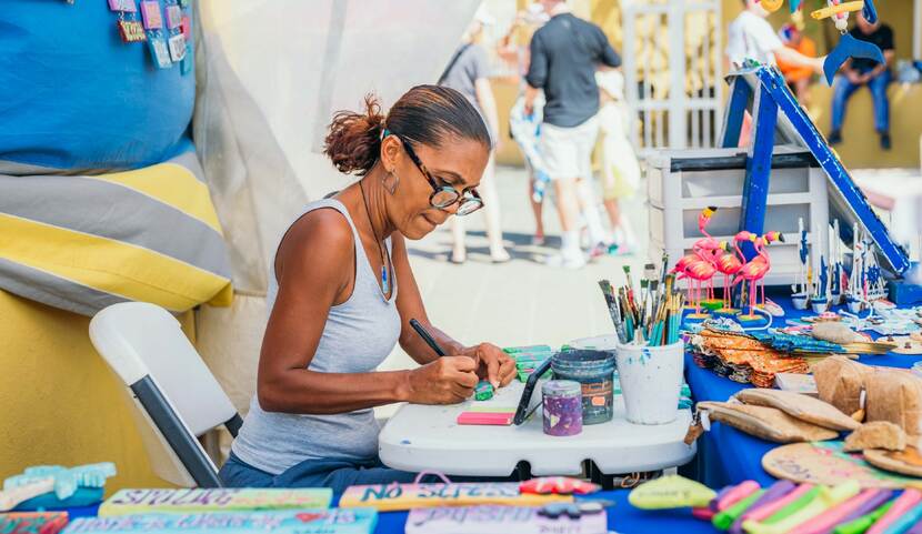 Vrouw maakt kunst in kraam op straat op Bonaire