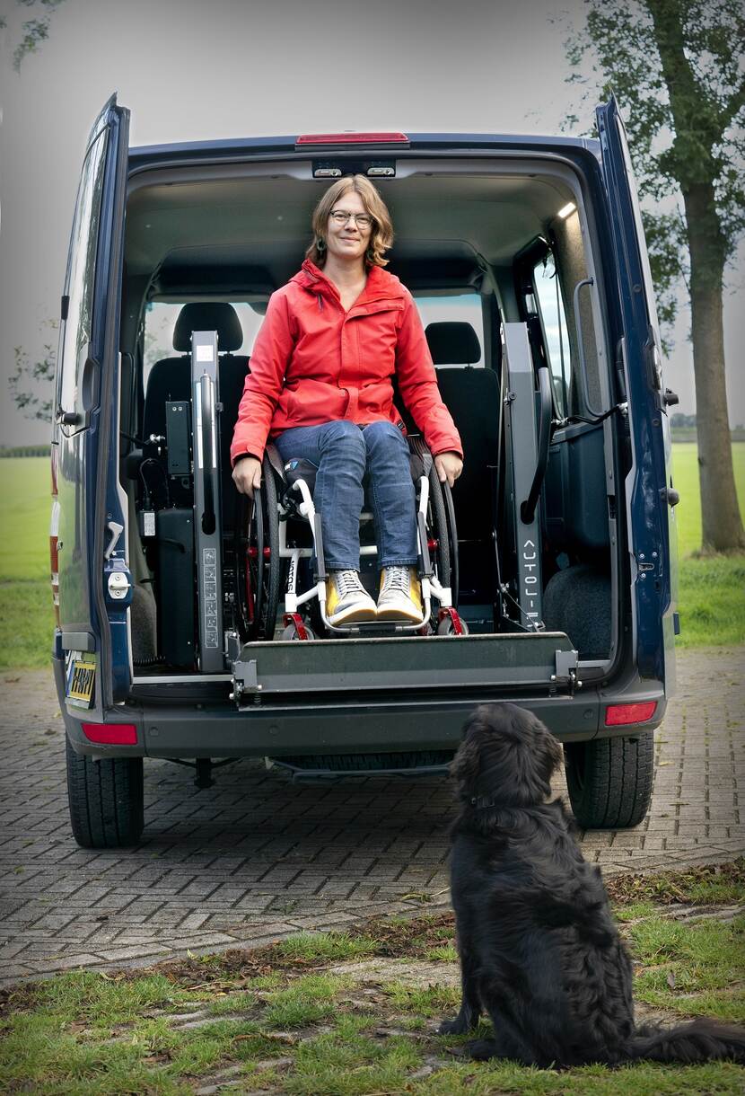 Alisa Hol wordt in haar rolstoel met een busje getransporteert