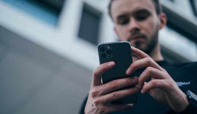 Foto van een man met een smartphone in zijn hand