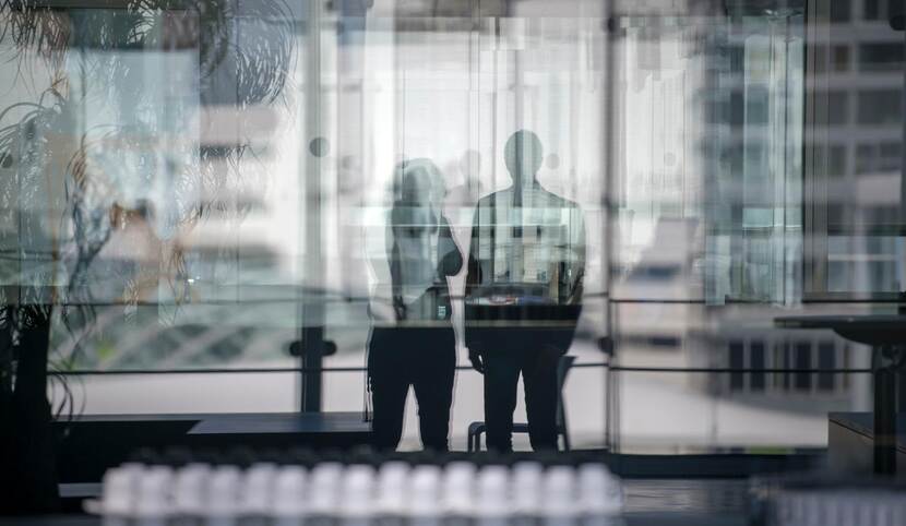 De silhouetten van een man en een vrouw door een glazen wand