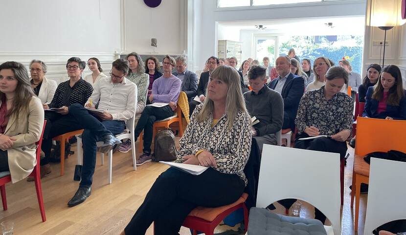 Mensen in een zaal tijdens de Nationale Consultatie UPR